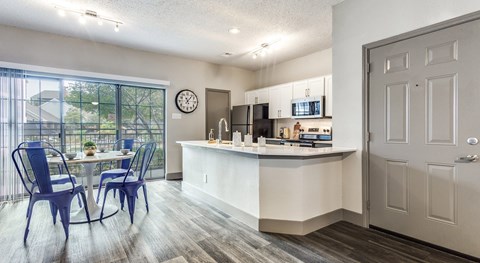 A kitchen with a dining table and chairs is shown.