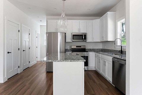 A modern kitchen with white cabinets and a central island.
