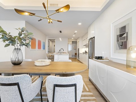 A modern dining room with a wooden table and chairs.
