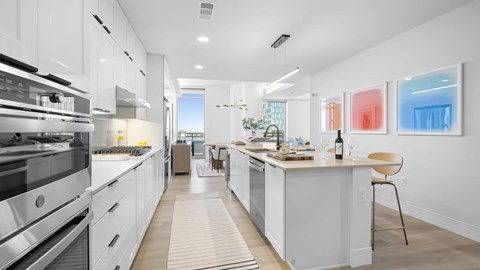 A modern kitchen with white cabinets and a large island.