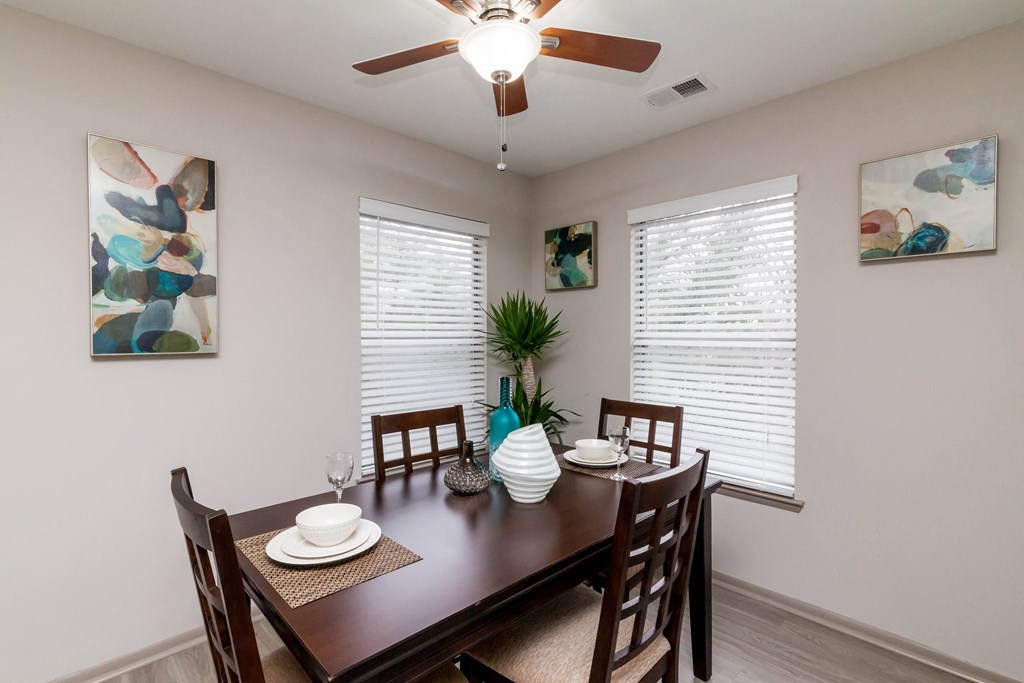 a dining room with a table and chairs and a ceiling fan