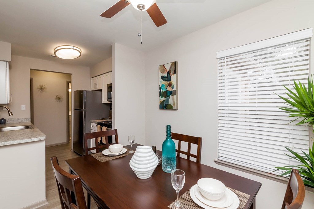 a dining room and kitchen with a table and chairs