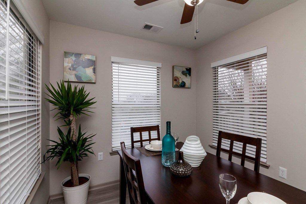 a dining room with a table and chairs and windows