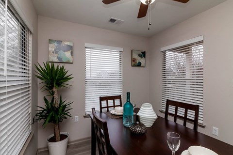 a dining room with a table and chairs and windows