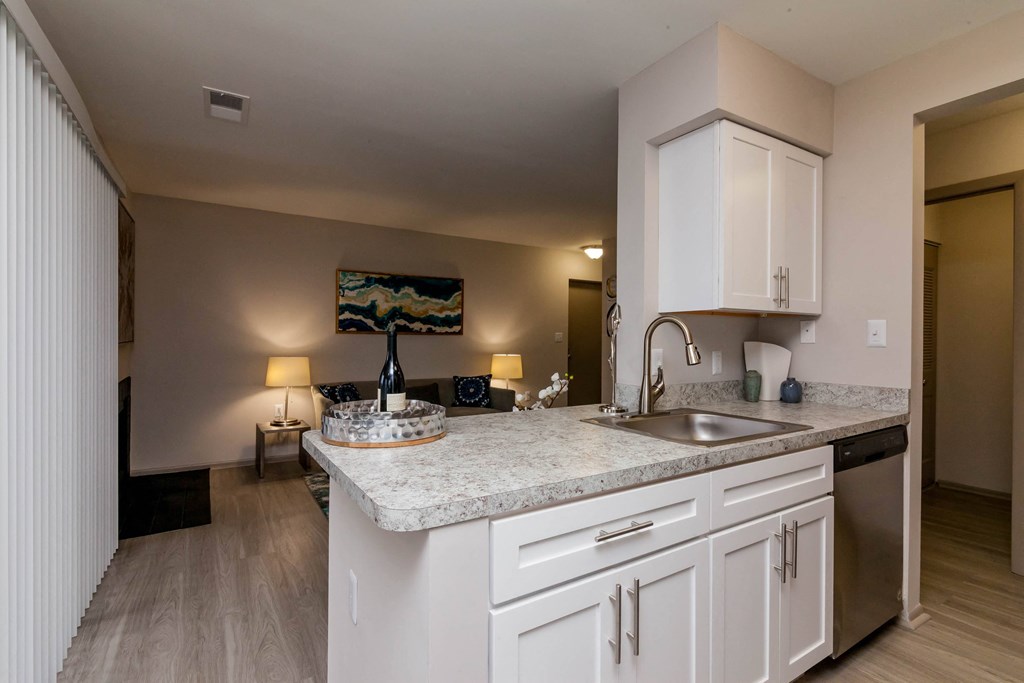 a kitchen with white cabinets and a sink and a counter top