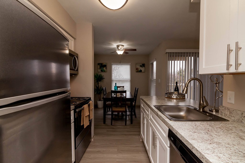 view of kitchen with stainless steel appliances and granite counter tops and a dining room table