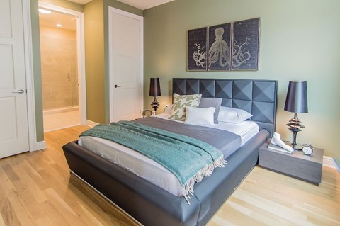 A bedroom with a bed, nightstand, and two lamps.