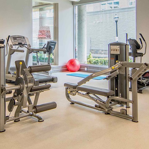 A gym with a red ball and a treadmill.