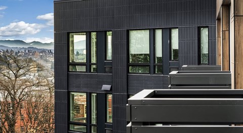 A modern building with a black facade and large windows.