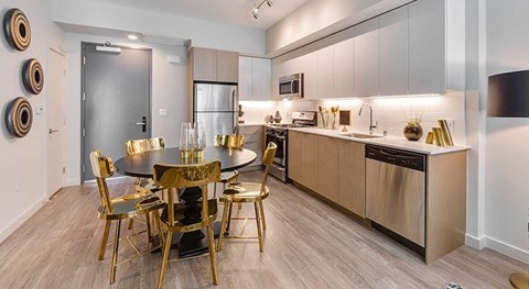 A modern kitchen with a dining table set for six.