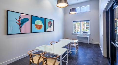 A dining room with a white table and chairs.