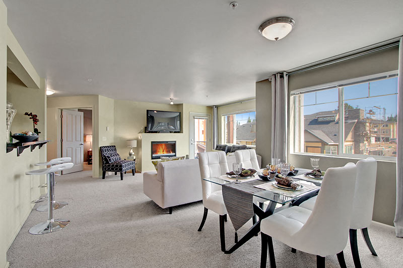 a living room and dining room with a table and chairs