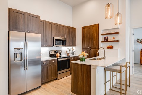 A modern kitchen with wooden cabinets and stainless steel appliances.
