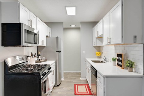 a kitchen with white cabinets and a stove and a refrigerator