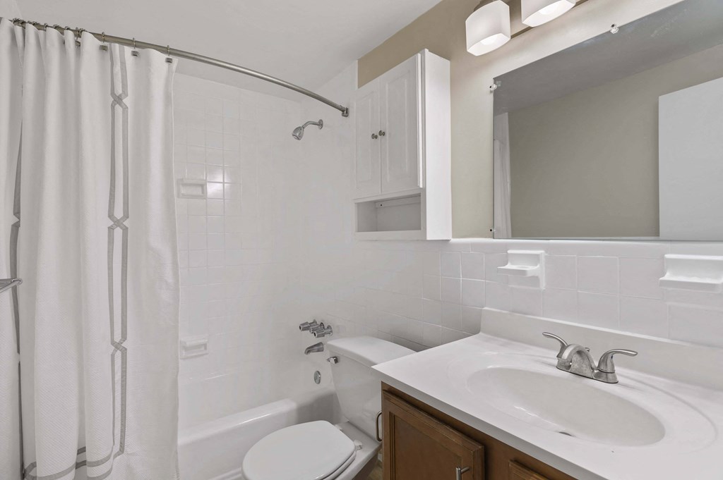 a white bathroom with a shower sink and toilet
