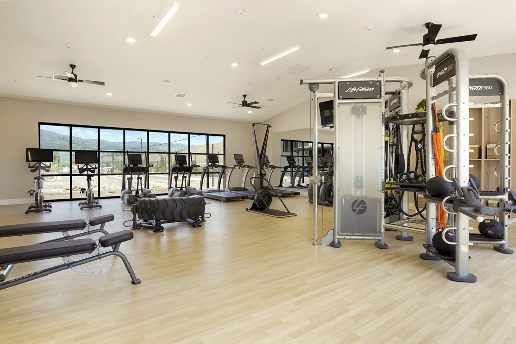 A gym with a variety of equipment including treadmills, weights, and exercise machines.
