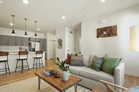 A modern living room with a white couch and a wooden coffee table.