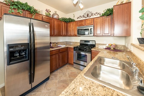 a kitchen with stainless steel appliances and granite counter tops