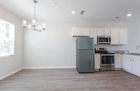 a kitchen with white cabinets and a stainless steel refrigerator