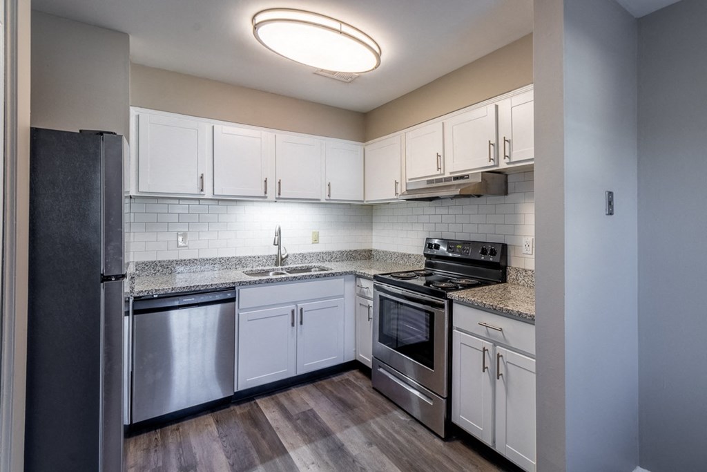 a kitchen with white cabinets and stainless steel appliances
