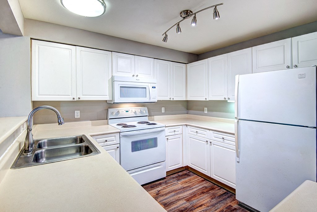Two-bedroom apartments in Issaquah, WA - Langara - Fully Equipped Kitchen with White Appliances, White Cabinets, and Dual Sink