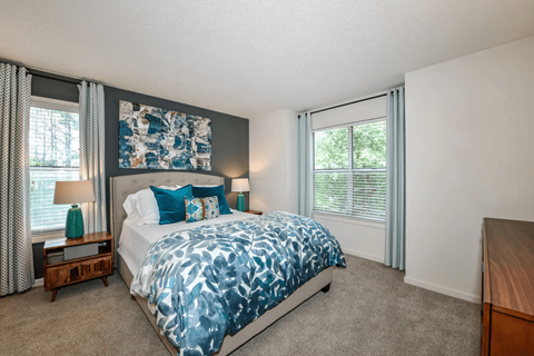 A bedroom with a large bed and a painting above it.
