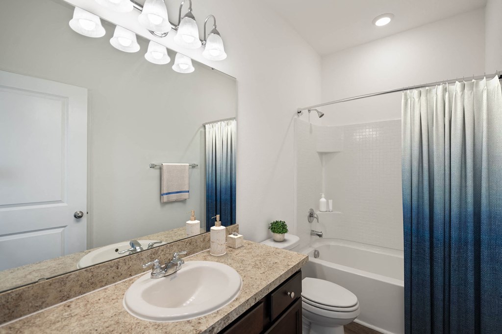 A bathroom with a sink, toilet, and shower.