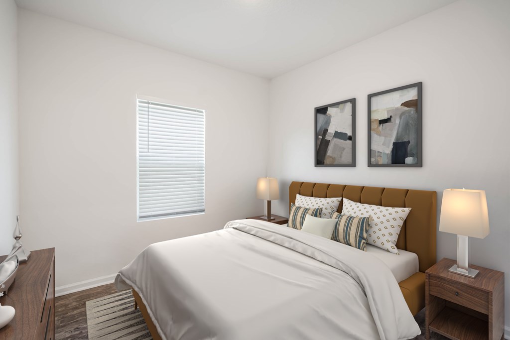 A bedroom with a bed, nightstands, and two framed pictures on the wall.