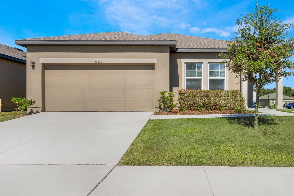 A house with a brown garage door and a driveway.