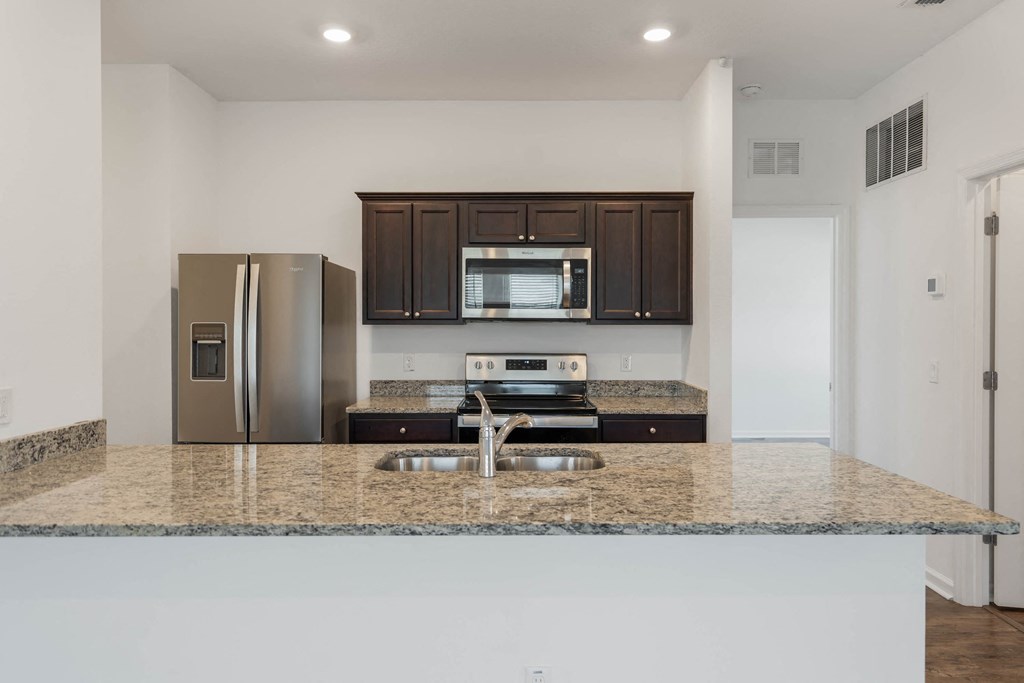 A kitchen with granite countertops and stainless steel appliances.