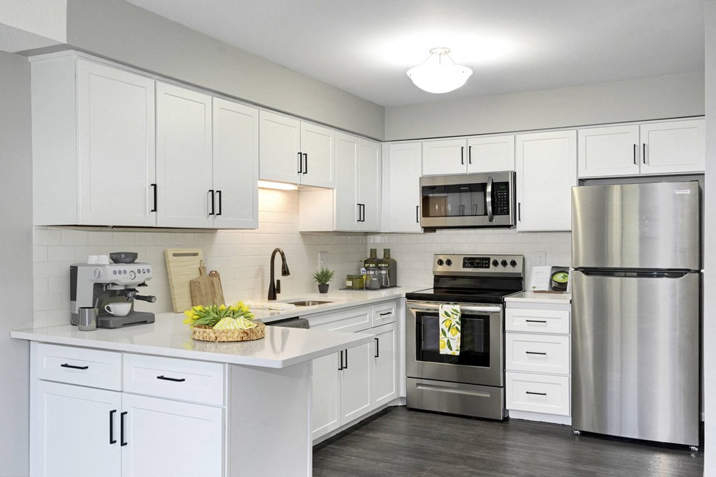 Laurel West End Apartments in Golden Valley, MN photo of kitchen with white cabinets, stainless-steel appliances and hardwood flooring