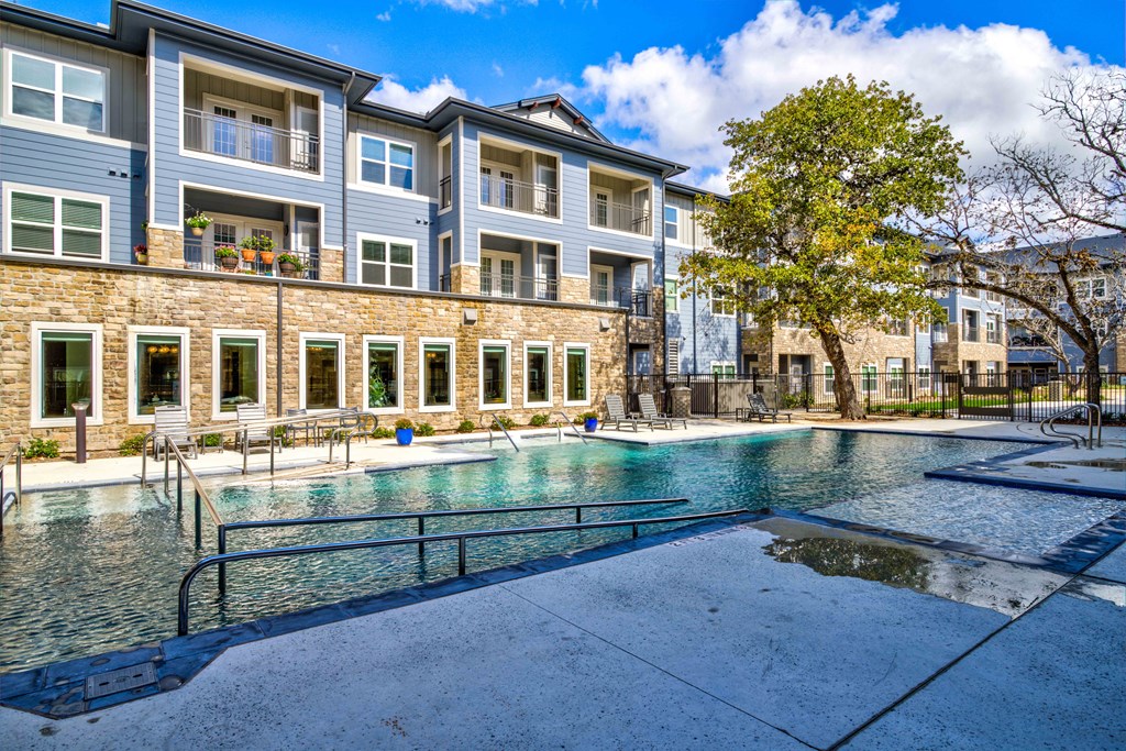 a swimming pool in front of an apartment building at LIV at Boerne Hills an Active Senior Community 62+, Texas, 78006