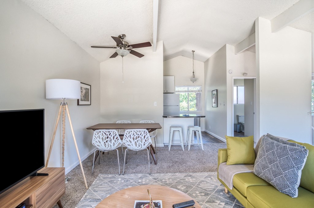 a living room with a couch a table and a ceiling fan