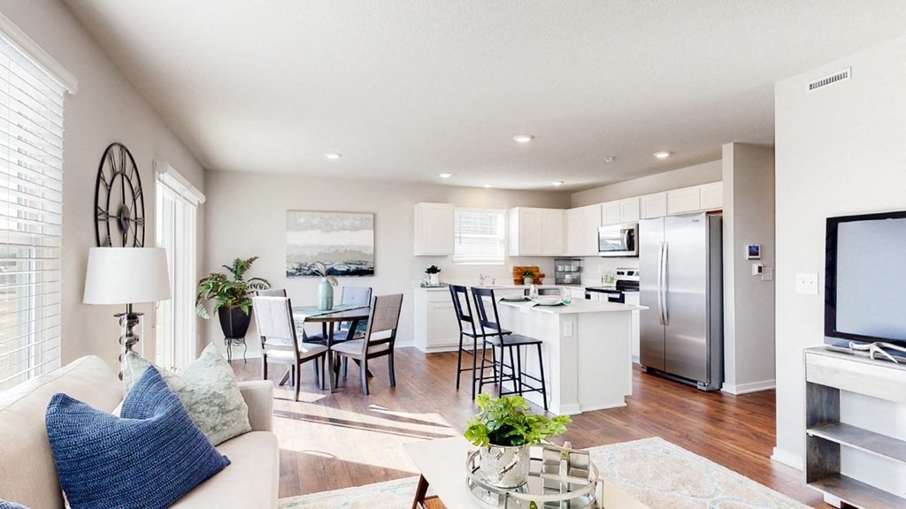 a living room with a kitchen and a table with chairs