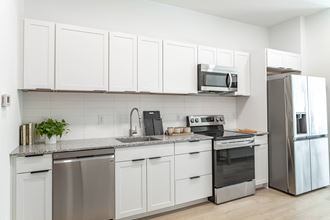 Luna Apartments in Nashville, TN photo of a kitchen with white cabinets and stainless-steel appliances