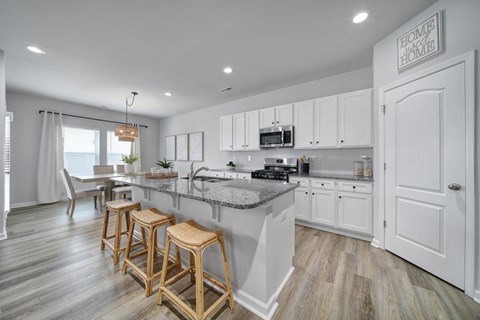 A kitchen with white cabinets and a granite countertop.