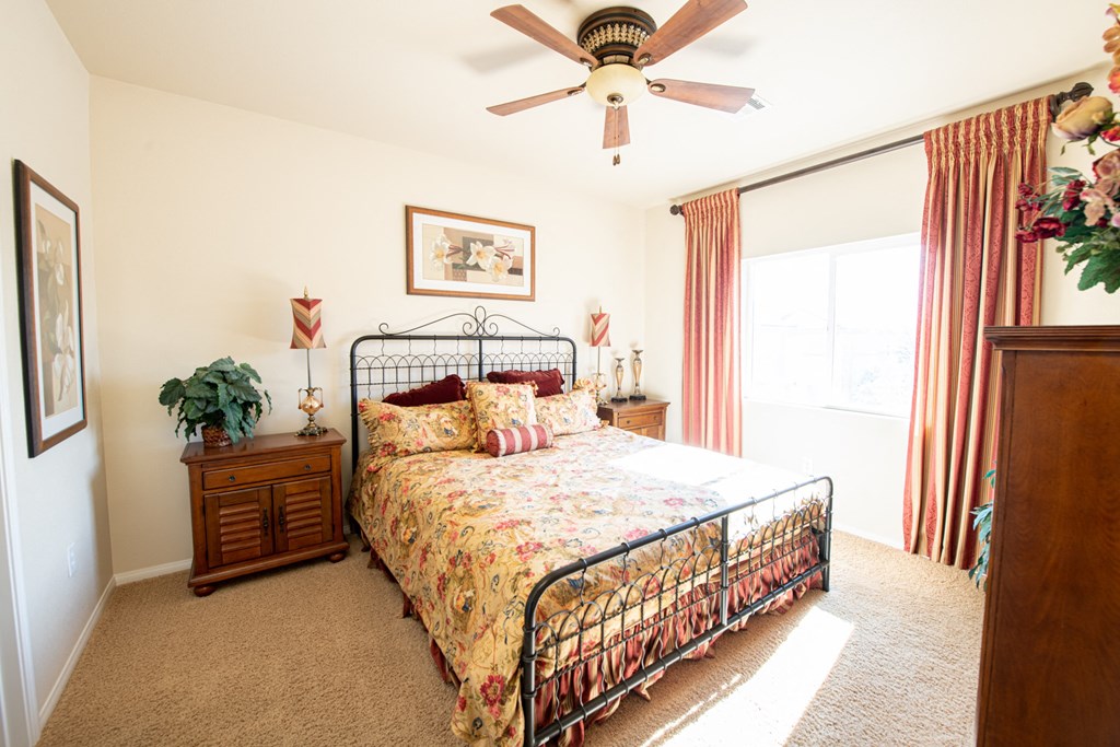 a bedroom with a bed and a ceiling fan