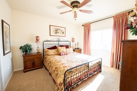 a bedroom with a bed and a ceiling fan