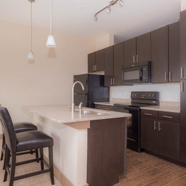a kitchen with black cabinets and a white counter top