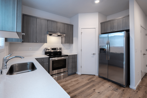 a kitchen with stainless steel appliances and white counter tops