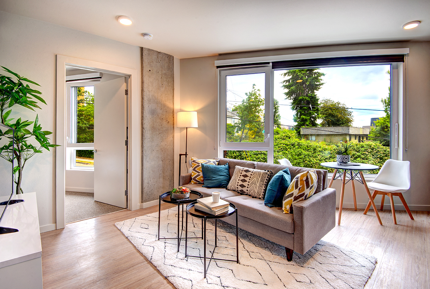 Downtown Seattle WA Apartments for Rent - Metroline Flats - Bright And Spacious Living Room With Wood-Style Flooring, Area Rug, Couch, Coffee Tables,  And Large Window