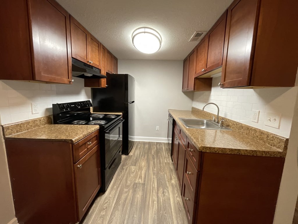 a kitchen with brown cabinets and a black stove top oven