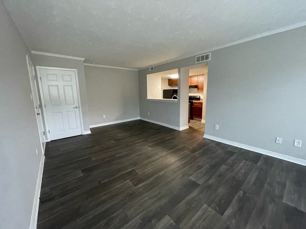 an empty living room with a hardwood floor