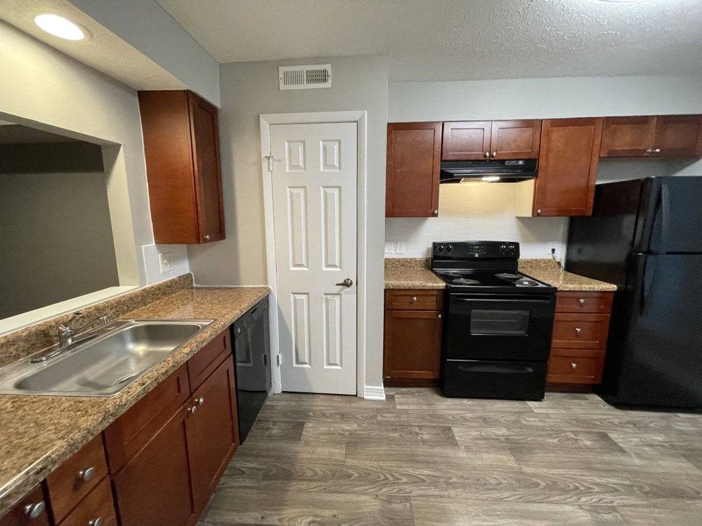 a kitchen with brown cabinets and a black stove top oven