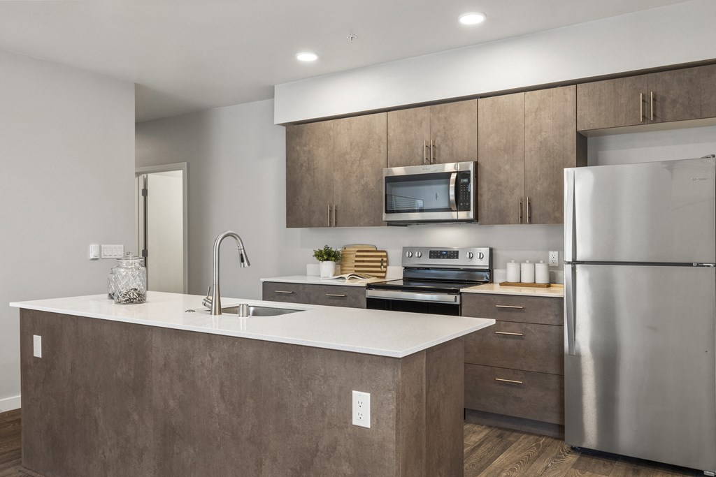 a kitchen with an island and stainless steel appliances,