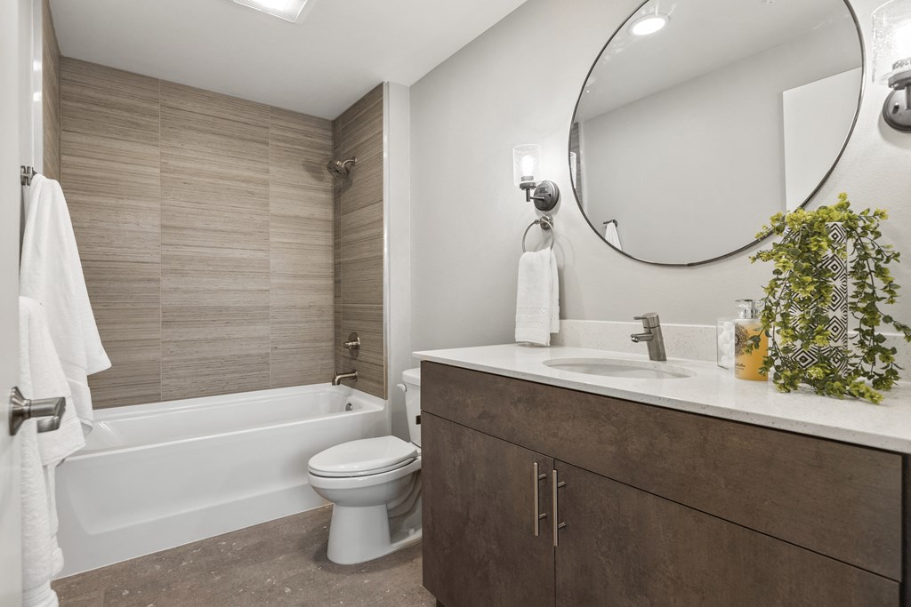 a bathroom with a toilet, sink, and bathtub,