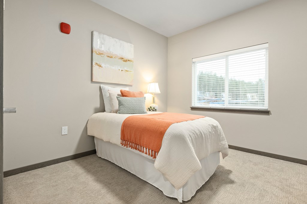 a bedroom with a bed and a window,