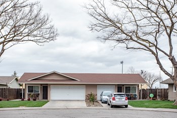 Modesto CA Apartments-Briggsmore Place Apartment Exterior with Lush Front Lawn and One and Two Car Garages
