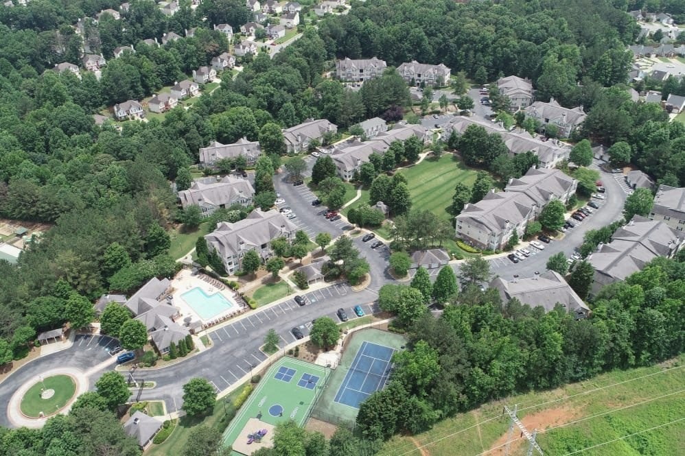 an aerial view of a neighborhood with houses and a tennis court