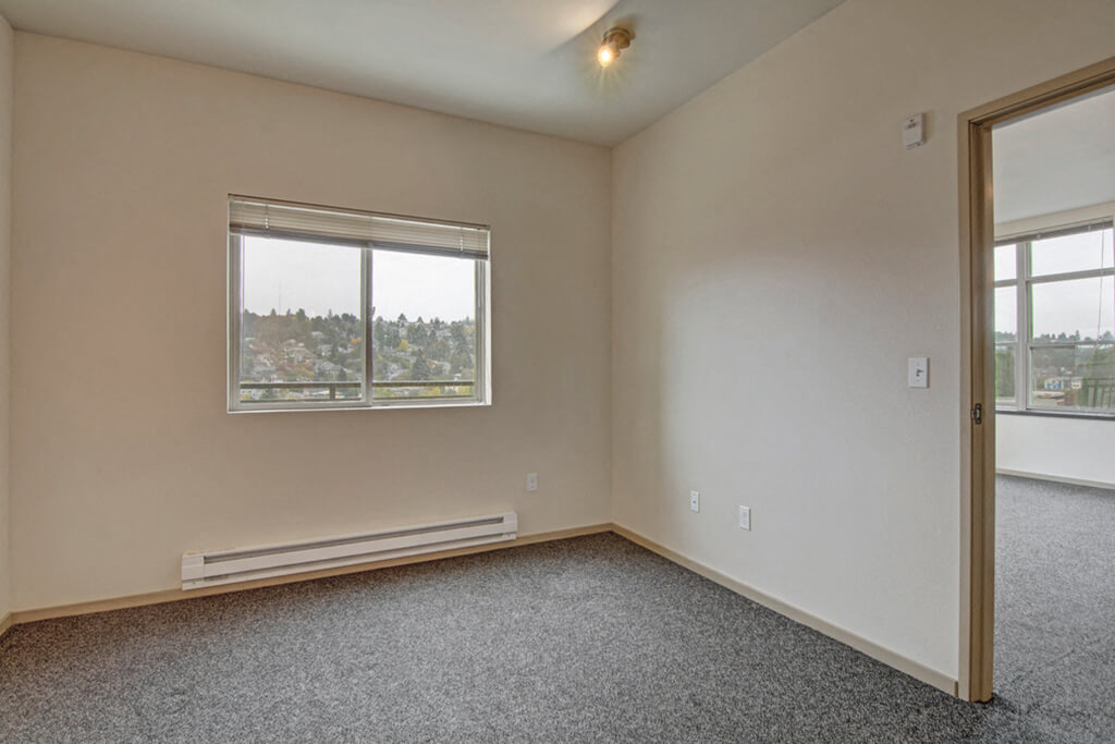 One-Bedroom Apartments in Fremont, WA - Epicenter - Bedroom with Carpeting, Window, Ceiling Light, and Air-Conditioning
